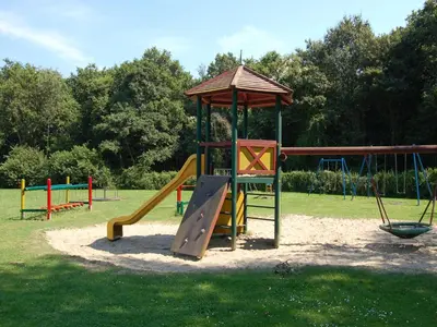 a playground with a slide in a park at Bungalow in Noordwijk near Lake & Beach in Noordwijkerhout