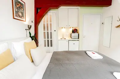 a bedroom with a white bed and a kitchen at Sunflower Amsterdam in Amsterdam