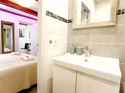 a bathroom with a sink and a bed in a room at Sunflower Amsterdam in Amsterdam