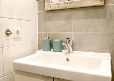 a bathroom sink with two cups on top of it at Sunflower Amsterdam in Amsterdam