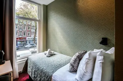 a bedroom with a bed and a window at Hotel Atlantis Amsterdam in Amsterdam
