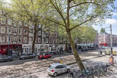 a busy city street with cars parked on the street at Hotel Atlantis Amsterdam in Amsterdam