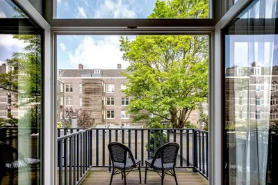 two chairs on a balcony with a view of a building at Hotel Atlantis Amsterdam in Amsterdam