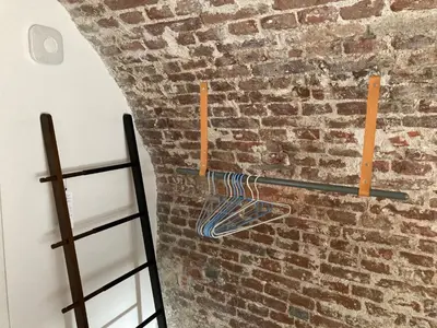 a room with a brick wall and a shelf at De Hoendervorst in Utrecht