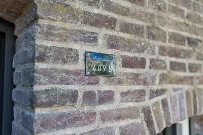 a clock on the side of a brick wall at De Hoendervorst in Utrecht