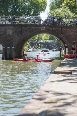 two people in kayaks on a river under a bridge at De Hoendervorst in Utrecht
