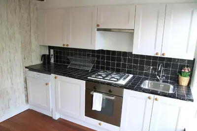 a kitchen with white cabinets and a sink and a stove at Bed & Breakfast The 9 Streets in Amsterdam