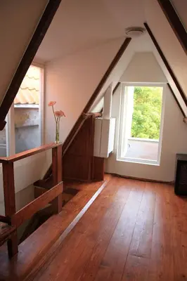 an attic room with a staircase and a window at Bed & Breakfast The 9 Streets in Amsterdam