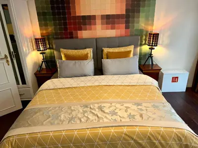 a large bed in a room with two lamps at Amsterdam 4 Holiday GuestRooms in Amsterdam