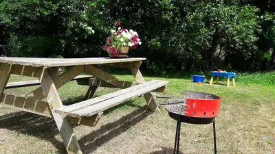 a picnic table with a grill and a pot of flowers at Noord-Hollands Hof Dream in Spijkerboor