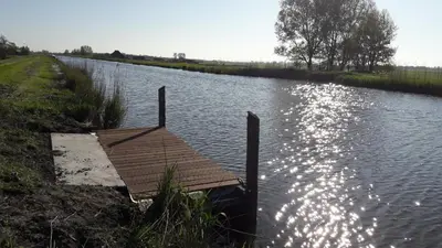 a wooden dock on the side of a river at Noord-Hollands Hof Dream in Spijkerboor