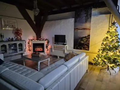 a living room with a white couch and a christmas tree at Noord-Hollands Hof Dream in Spijkerboor
