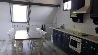 a kitchen with a table with white chairs and a sink at Noord-Hollands Hof Dream in Spijkerboor