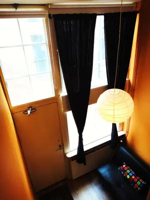 a room with a window with a couch and a lamp at Orange Suite Studio in Amsterdam