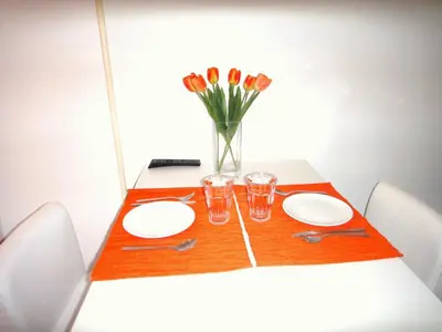 a table with plates and glasses and a vase of flowers at Orange Suite Studio in Amsterdam