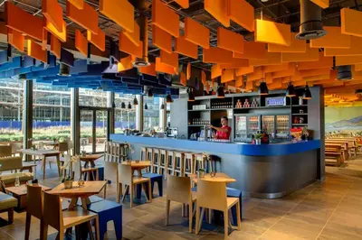 a restaurant with orange lighting and tables and chairs at MEININGER Hotel Amsterdam City West in Amsterdam