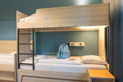two bunk beds in a room with a desk at MEININGER Hotel Amsterdam City West in Amsterdam