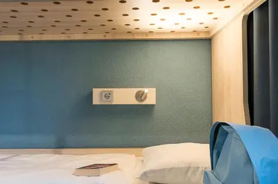 a bedroom with a green wall and a bed at MEININGER Hotel Amsterdam City West in Amsterdam