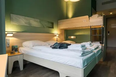 a bedroom with a large bed with white sheets at MEININGER Hotel Amsterdam City West in Amsterdam