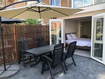 a table and chairs with an umbrella on a patio at Casa del Cisne 2 in Zandvoort
