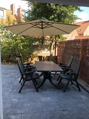 a picnic table and chairs with an umbrella at Casa del Cisne 2 in Zandvoort