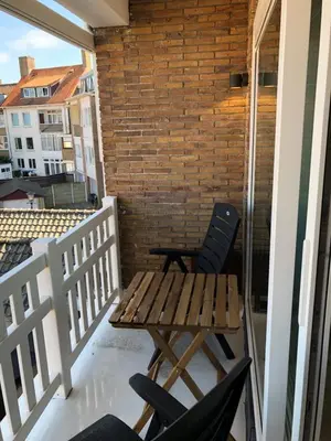 a patio with two chairs and a table on a balcony at Casa del Cisne 2 in Zandvoort