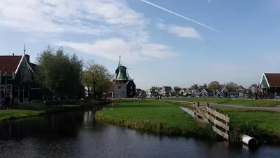 a river with a church with a green roof at FortEdam in Edam