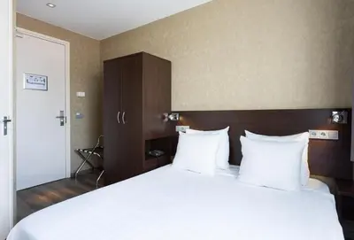 a bedroom with a large bed with white sheets and pillows at Hotel Espresso in Amsterdam