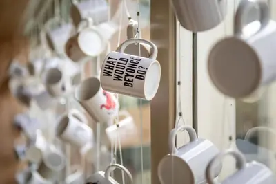 a bunch of coffee cups hanging in a window at Hotel Espresso in Amsterdam