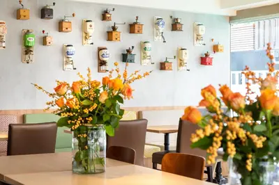 a table with vases of flowers and pictures on the wall at Hotel Espresso in Amsterdam