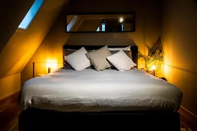a bedroom with a large bed with white sheets and pillows at Bambu Sleep Boutique in Haarlem