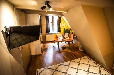 a living room with a table and a tv at Bambu Sleep Boutique in Haarlem