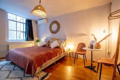 a bedroom with a bed and a table and chairs at Bambu Sleep Boutique in Haarlem