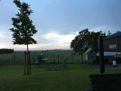 a table and chairs and a tree in a field at Appartement Zandwerven 23 in Spanbroek
