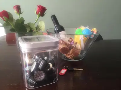 a plastic container with a bottle of wine and a flower at Bed en Beach in Katwijk aan Zee
