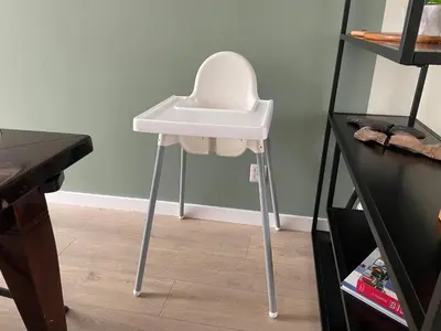 a white high chair sitting in a room next to a desk at Bed en Beach in Katwijk aan Zee