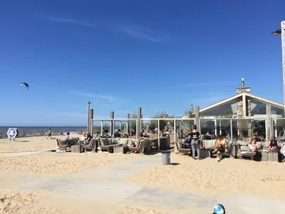 a group of people sitting in chairs on the beach at Bed en Beach in Katwijk aan Zee