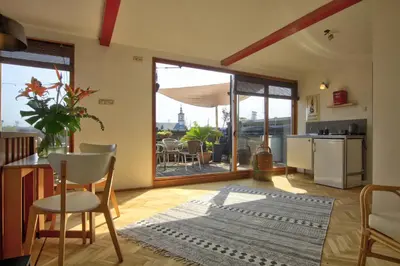 a living room with a table and chairs and a kitchen at Rooftop studio near Amsterdam Castle (Muiden) in Muiden