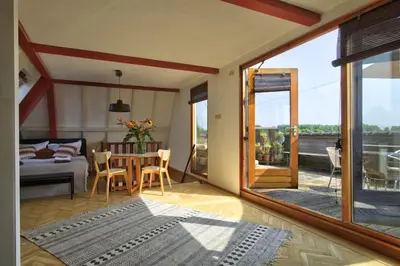 a living room with a table and a bedroom at Rooftop studio near Amsterdam Castle (Muiden) in Muiden