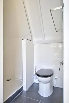 a white bathroom with a toilet and a shower at Rooftop studio near Amsterdam Castle (Muiden) in Muiden