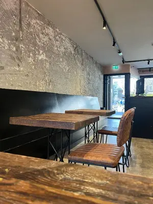 a row of wooden tables and chairs in a restaurant at Amigo Budget Hotel in Amsterdam