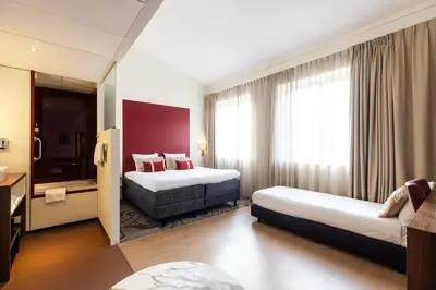 a hotel room with two beds and a window at City Hotel Gouda, WorldHotels Crafted Collection in Gouda