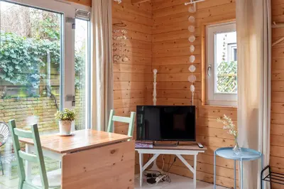 a room with a desk and a tv and a window at Moyo Kijani in Zandvoort