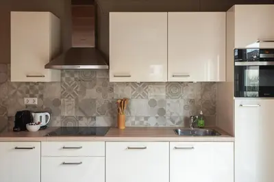 a kitchen with white cabinets and a sink at Moyo Kijani in Zandvoort