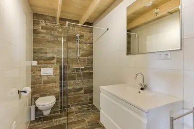 a bathroom with a shower and a toilet and a sink at Moyo Kijani in Zandvoort