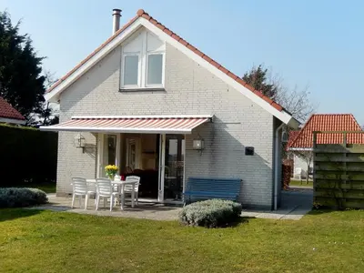 a house with a table and chairs in a yard at Holiday Home Stern Comfort-3 by Interhome in Noordwijkerhout