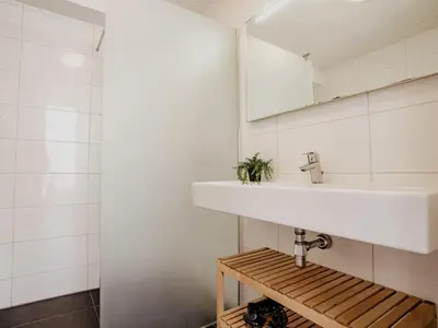 a bathroom with a sink and a mirror at Holiday Home Assum by Interhome in Uitgeest