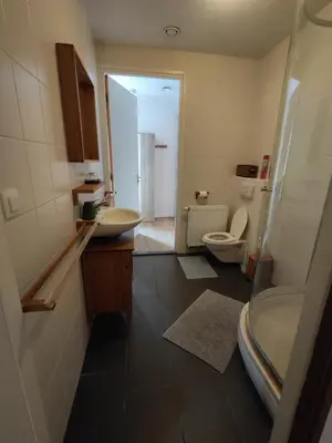 a bathroom with two sinks and a toilet at Huis van Steen in Lelystad
