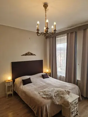 a bedroom with a large bed and a chandelier at Pension Zee en Duinzicht in Zandvoort
