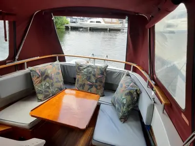 a seat in the back of a boat with a table at Motorjacht Flint in Amsterdam